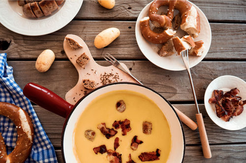 Rezept Bierfondue mit Wurst und Speck, dazu Laugenbrezeln und Kartoffeln