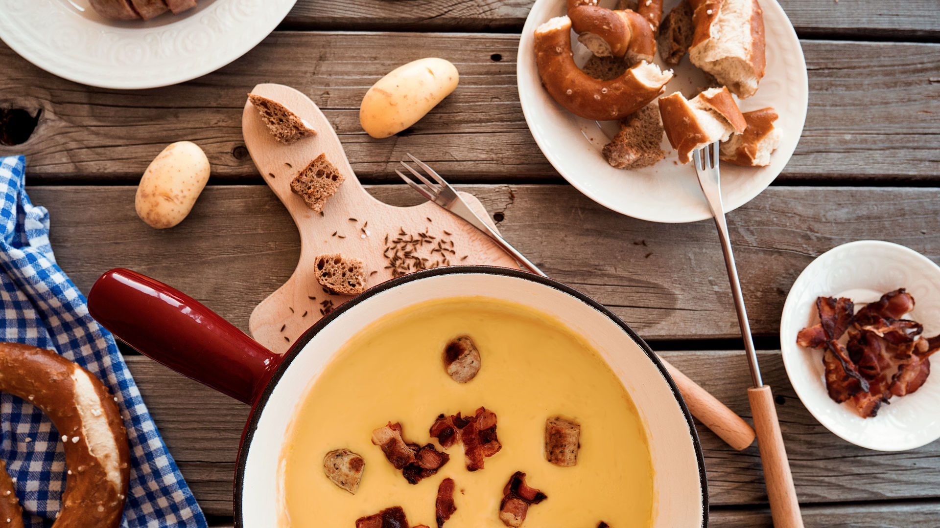 Rezept Bierfondue mit Wurst und Speck, dazu Laugenbrezeln und Kartoffeln